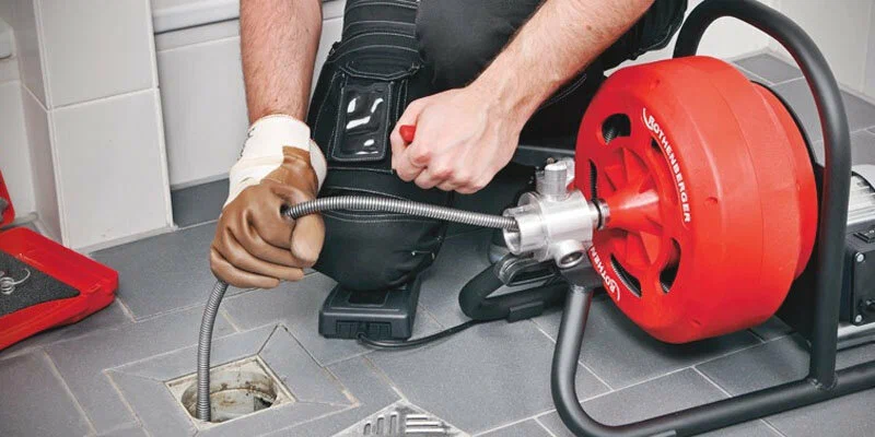 Plumber using a drain-cleaning machine in Deltona