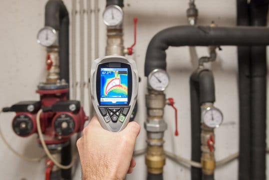Plumber using a thermal imaging camera to inspect pipes in Deltona