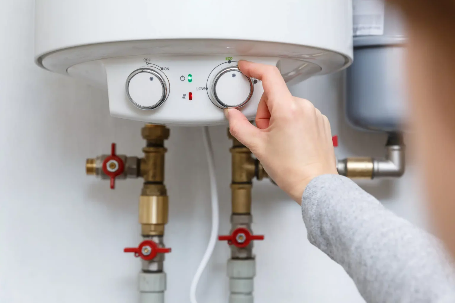 Homeowner adjusting the temperature controls on a water heater in Deltona